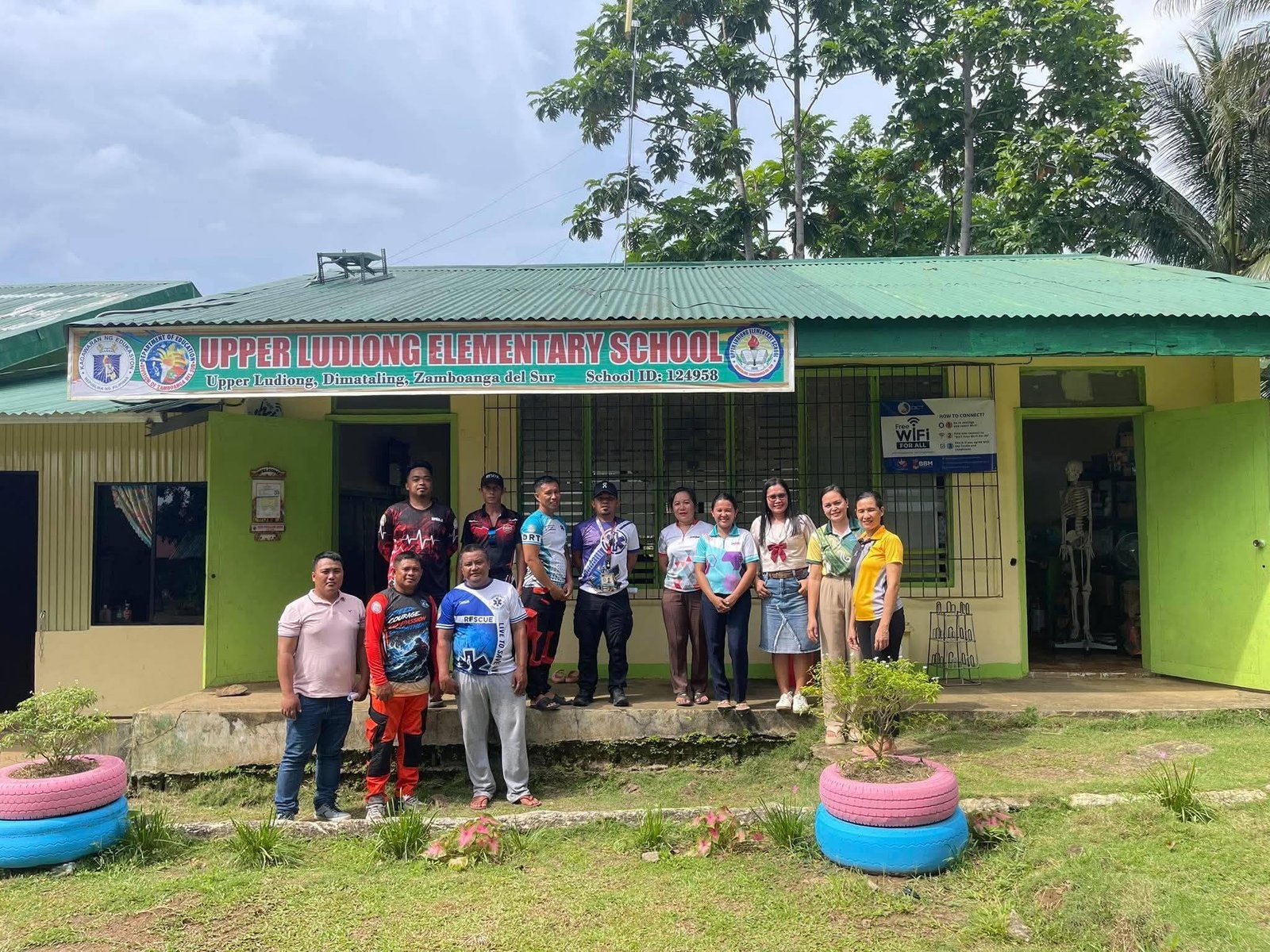 Disaster response and school personnel stand outside Upper Ludiong Elementary School in Dimataling.
